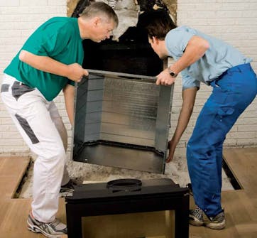 Takkasydän avotakkaan: Takkasydän nostetaan pois irrallaan olevasta kammiosta Takkasydän avotakkaan: Takkasydän nostetaan pois irrallaan olevasta kammiosta